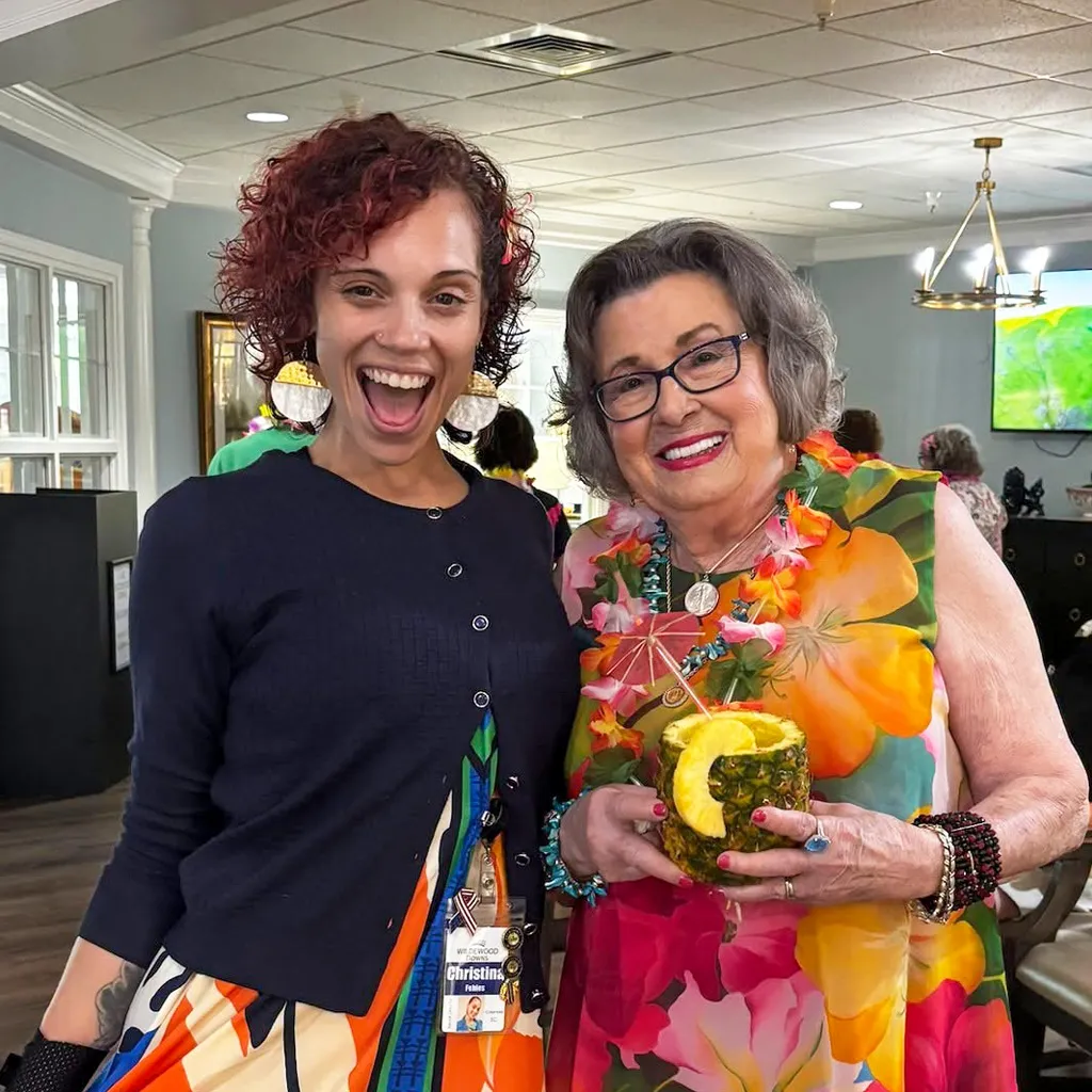 Member in colorful dress holding tropical drink